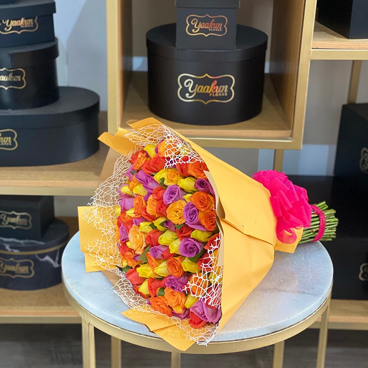 Maxi ramo de 100 rosas naranja, amarillo y lila con papeles y malla