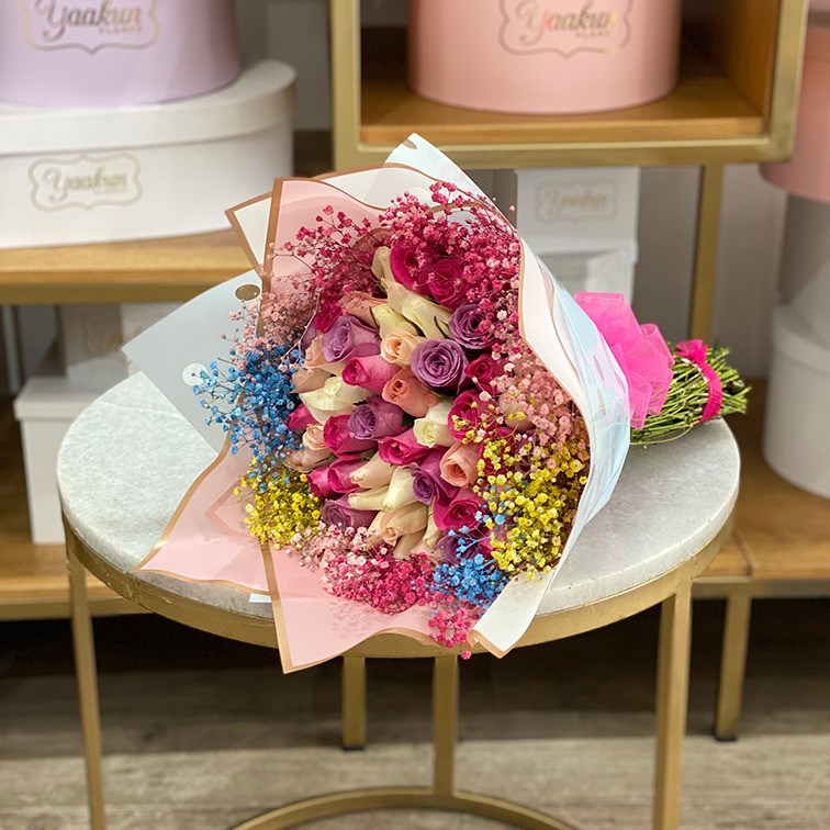 Ramo de 50 rosas tonos rosas con gypso de colores en envoltura papel coreano
