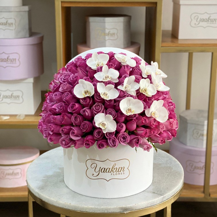 150 rosas lilas  en caja redonda blanca con 12 orquideas phalenosis blancas