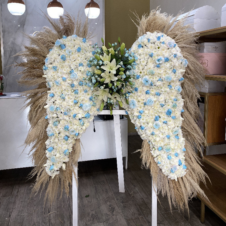 Arreglo fúnebre de alas con 200 rosas y toques azules