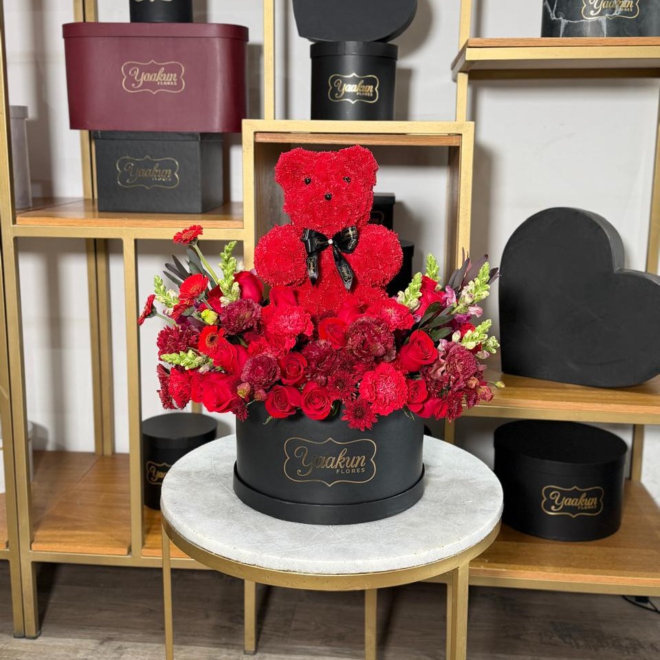 Caja circular negra con escultura de osito jarden en tonos rojos