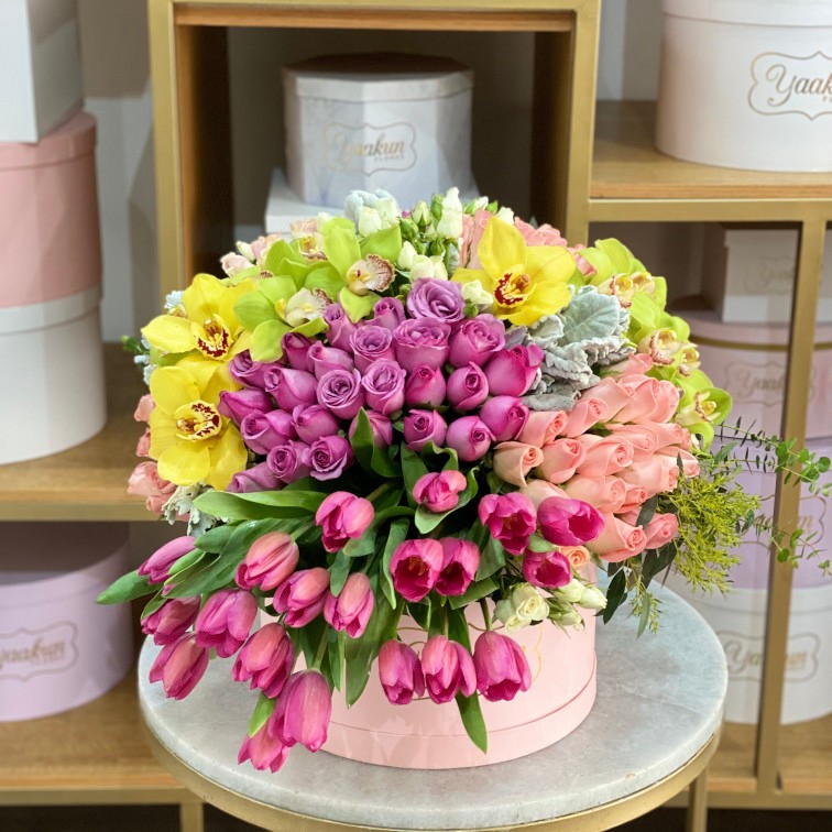 Caja circular rosita con con rosa y tulipanes rosas y detalles de orquídea verde y amarilla