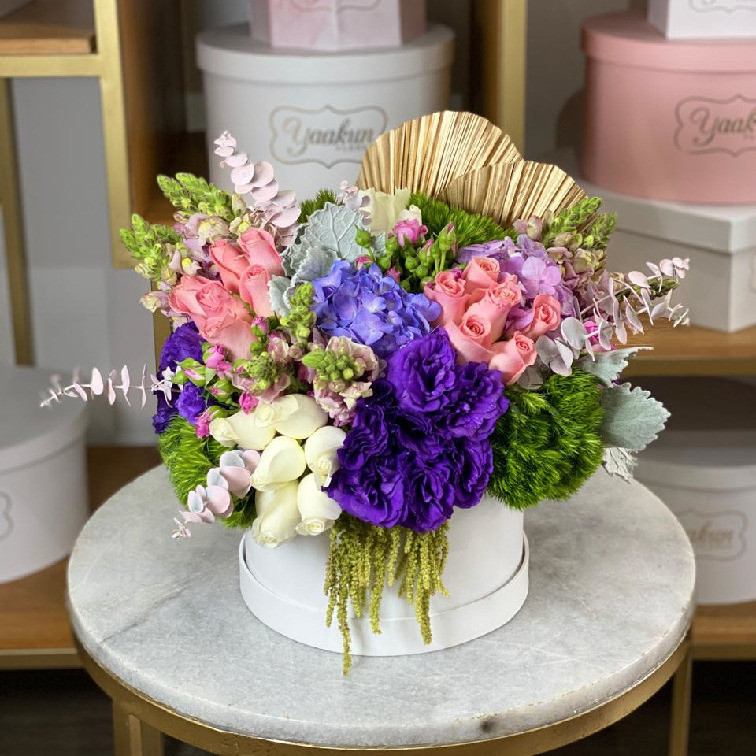Caja circulara blanca con 50 rosas, lisianthus, hortensias, peritos y abanicos dorados
