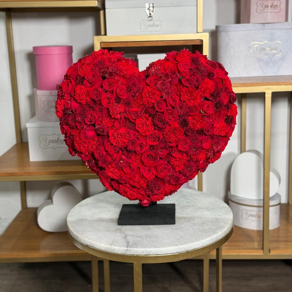 Escultura de corazón chico en tonos rojos, flores mixtas