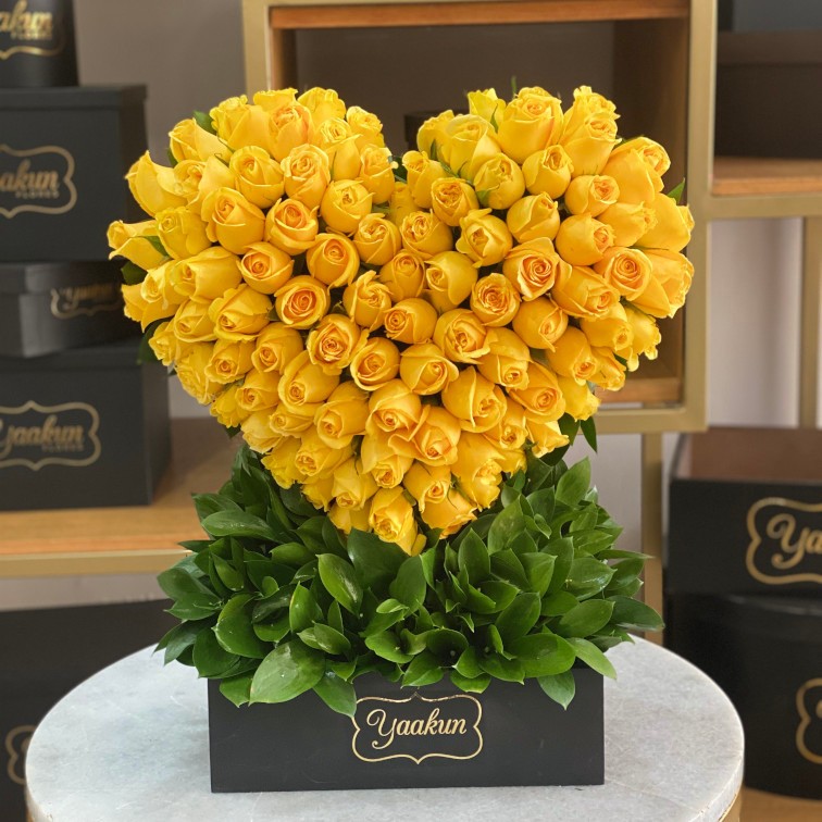 ESCULTURA DE CORAZÓN CON 100 ROSAS AMARILLAS EN CAJA NEGRA