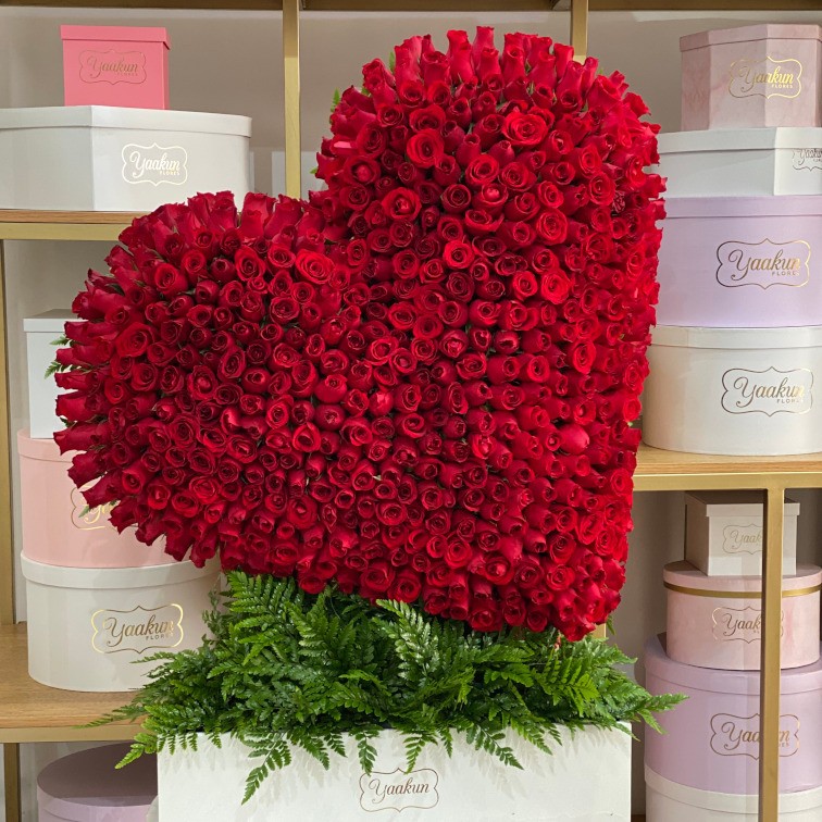 Escultura de corazón inclinado de 500 rosas rojas en caja blanca