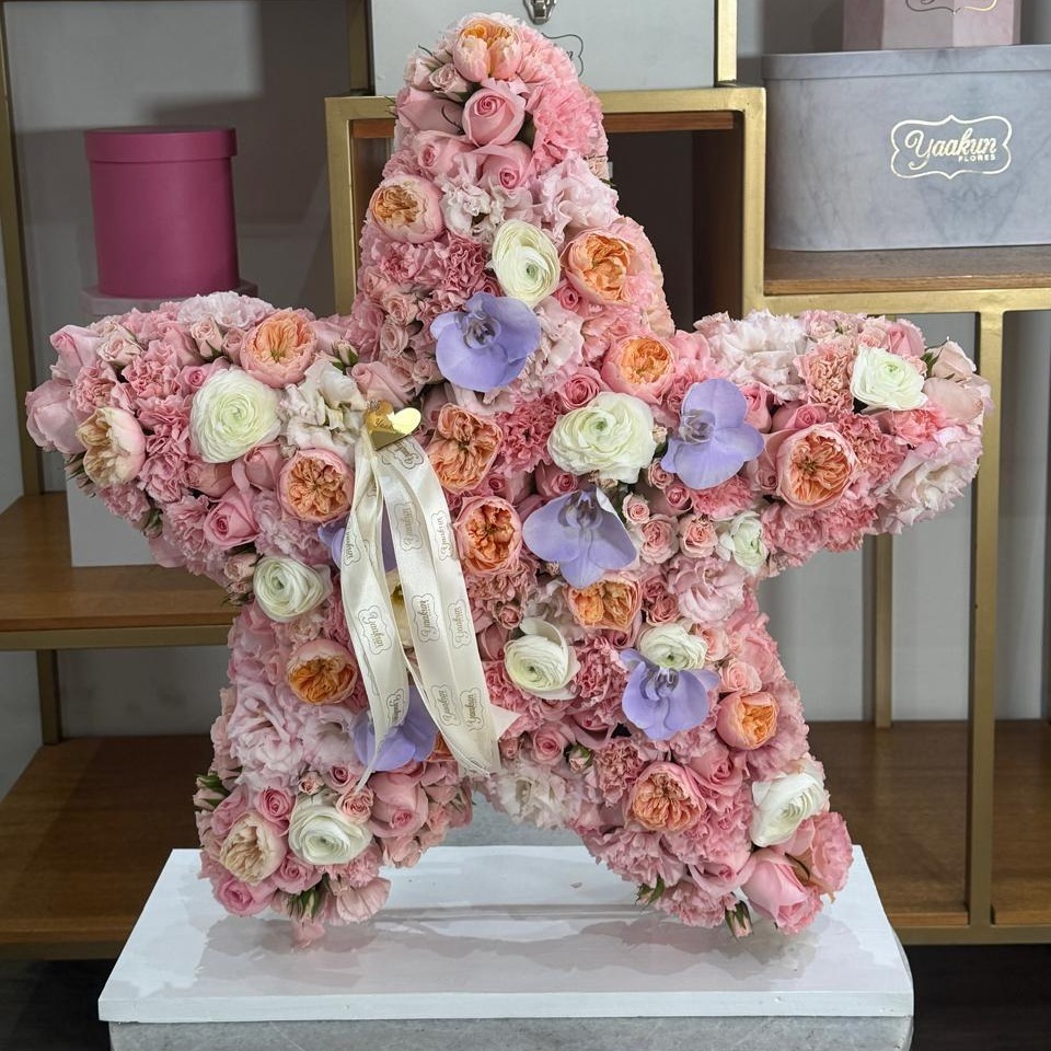 Escultura de estrella en tonos rosas con toques de inglesa y orquídea lila