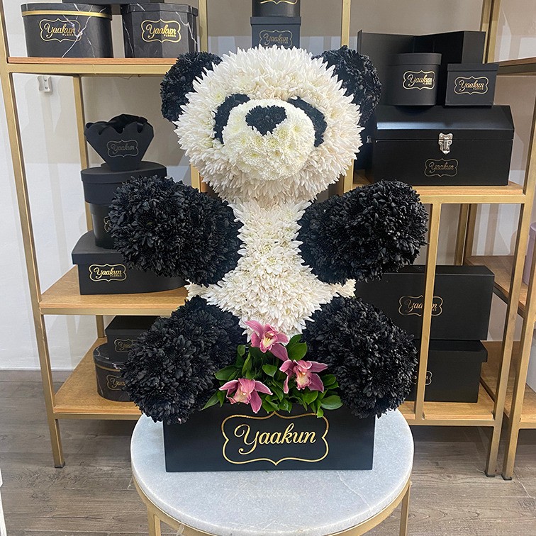 Escultura de oso panda en caja negra con 3 orquídeas cymbidium