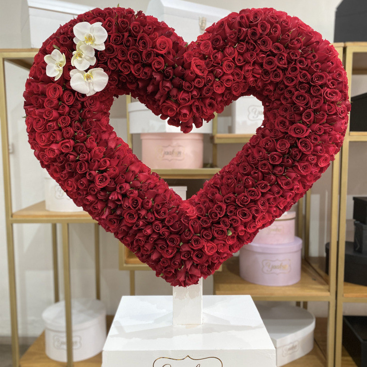 ESCULTURA DE SILUETA DE CORAZON DE 800 ROSAS ROJAS CON ORQUIDEAS