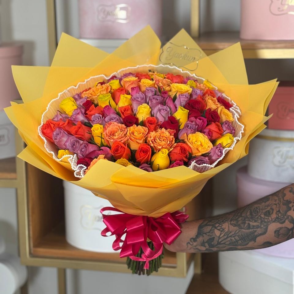 Maxi ramo de 100 rosas naranja, amarillo y lila con papeles y malla