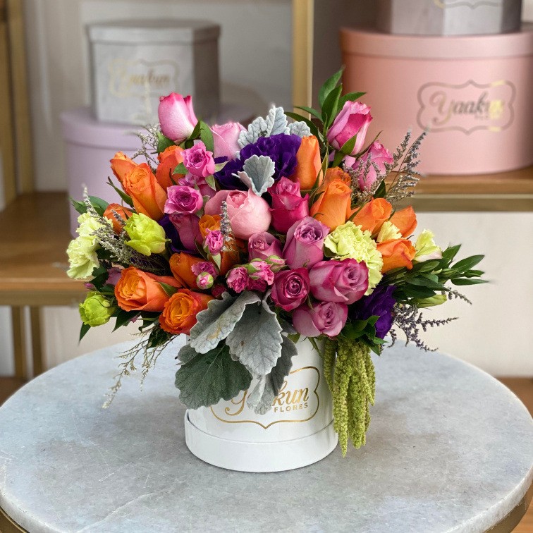 MINI CAJA CIRCULAR BLANCA CON 50 ROSAS LILAS Y NARANJAS LISIANTHUS Y FOLLAJES FINOS
