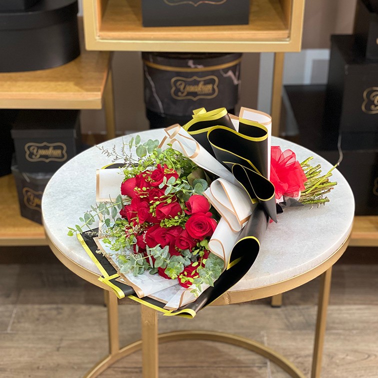 Ramo de 24 rosas rojas con follajes y papel celofan