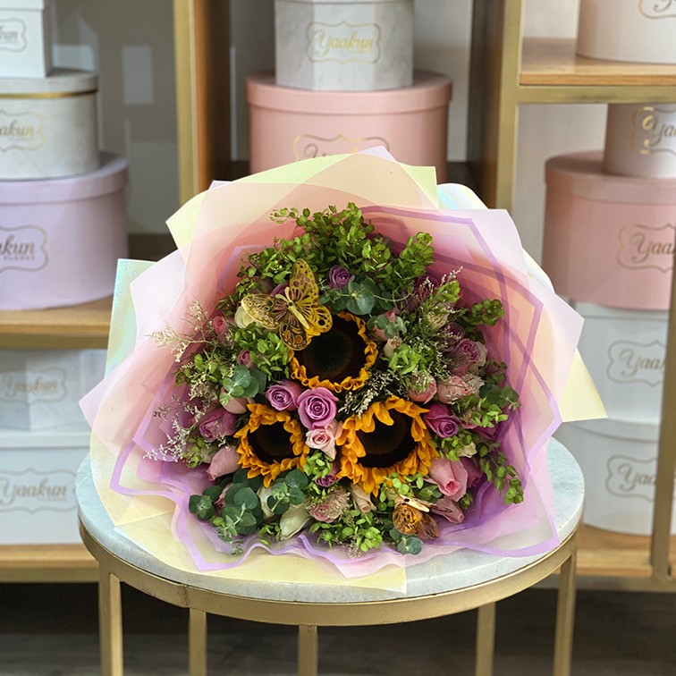 Ramo de 50 rosas en tono pastel con follajes y 3 girasoles y mariposas