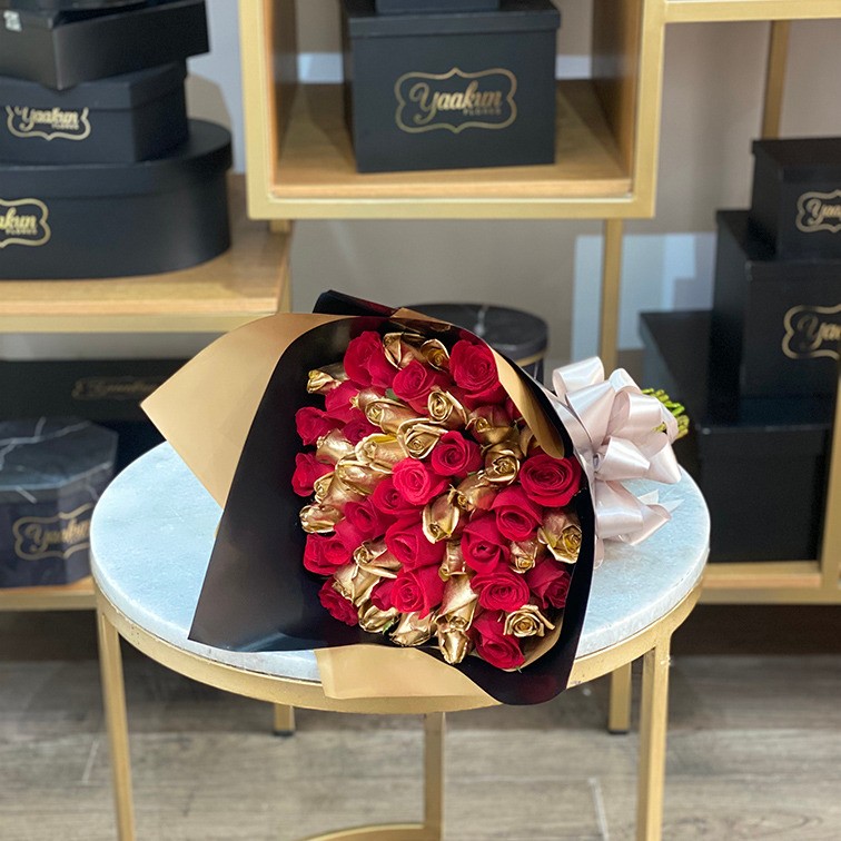 Ramo de 50 rosas rojas & doradas con papel celofan