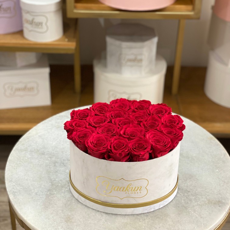 Rosas eternas en caja ovalada blanca marmoleada con rosas rojas